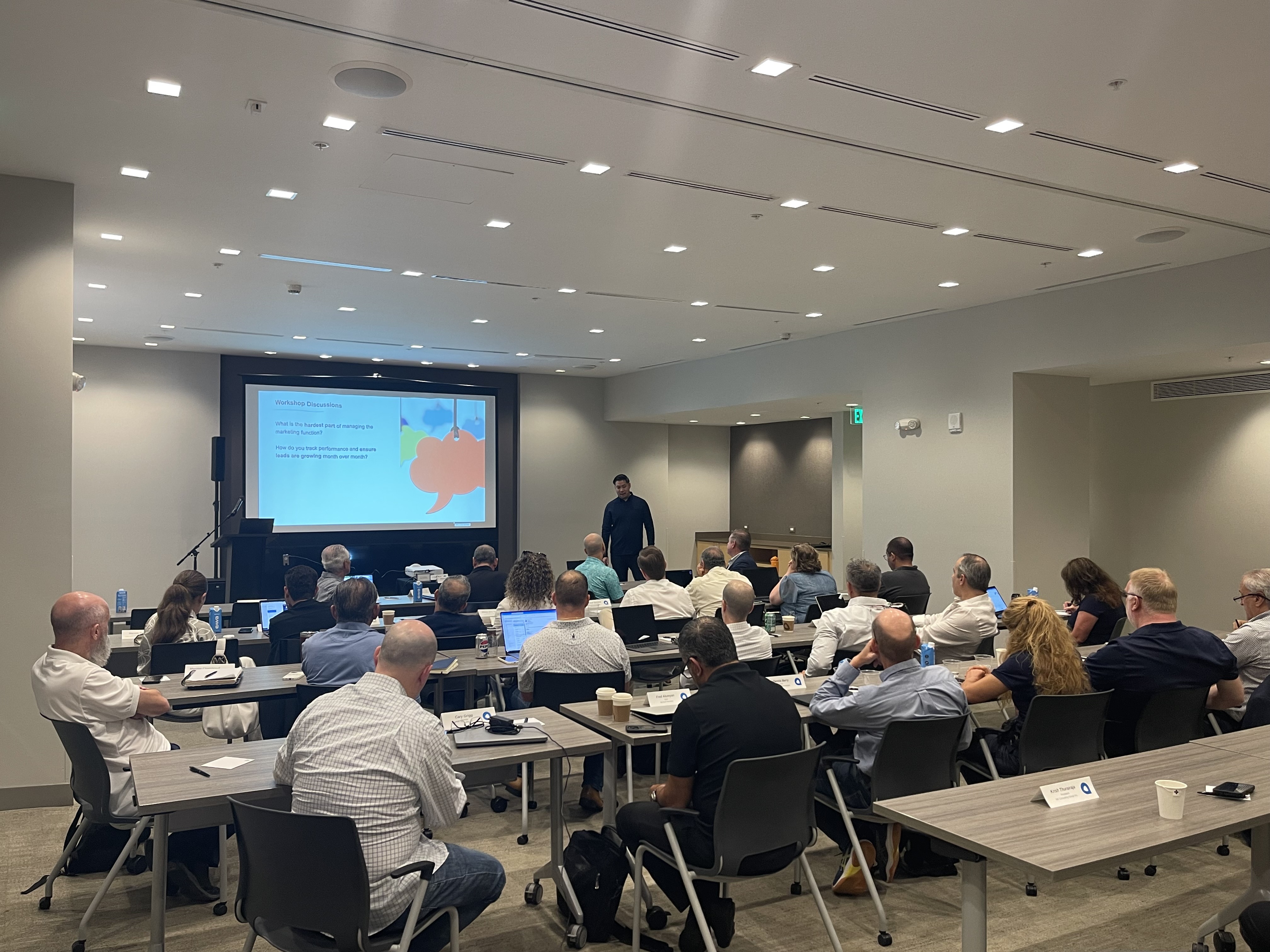 Alex speaking to a group about growth, marketing, and business systems